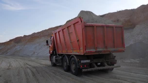 Tung lastbil transporterar sand på dammiga grusväg — Stockvideo