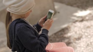 Çocuk cep telefonu kullanıyor. Çocuk ekrandaki aygıtlara bakıyor.