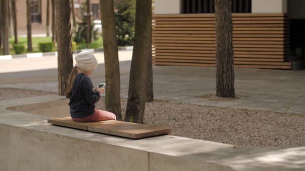 Kind gebruikt een mobiele telefoon. Kid kijkt naar het scherm van de apparaten. — Stockvideo