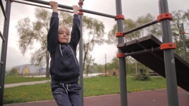 4K Kızı açık hava sporları oyun parkında ABS egzersizleri yapıyor