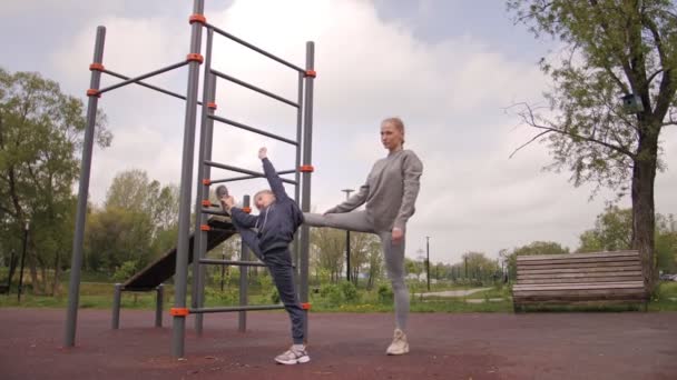 4K Μητέρα και κόρη κάνει ασκήσεις στην υπαίθρια παιδική χαρά αθλητισμού — Αρχείο Βίντεο