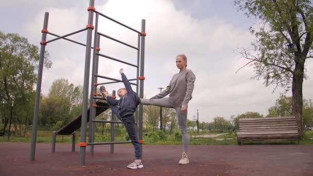 4K Moeder en dochter doen oefeningen op openlucht sport speeltuin — Stockvideo