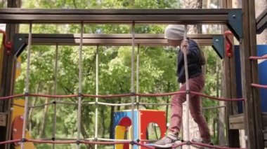 4K SLOW MOTION Parktaki çocuk parkında oynayan şık kız