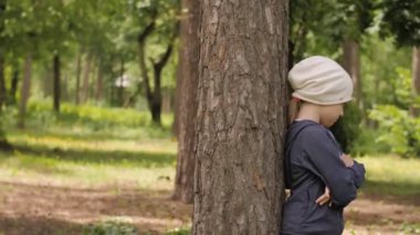 Hayal kırıklığına uğramış tatlı kız, güceniyor, yeşil çayırda duruyor.