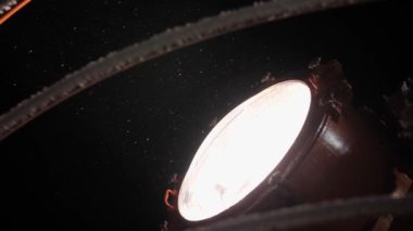 Gecenin karanlığında büyük bir geminin spot ışığı ve kar yağışı.