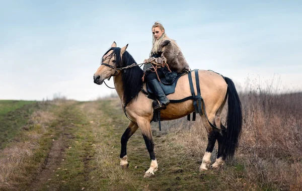 Warrior viking blonde female riding a horse - Medieval movie scene