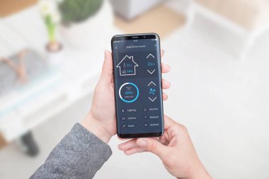 Akıllı ev kontrol app kadın elinde mobil cihazlar için. Oturma odası iç arka planda.