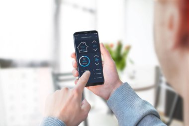 Adam akıllı ev kontrol app oturma odası iç aydınlatma denetlemek için kullanın.
