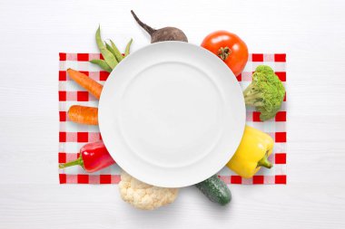 Vegan sebze konseptiyle boş levha ve kırmızı beyaz masa örtüsü sebze. Düz yatıyordu.