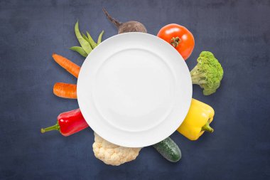 Boş levha ve arka plan üzerinde siyah yüzey sebze vejetaryen vegan cousine kavramı.