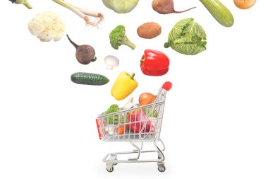 Isolated vegetables fall into market cart. clipart