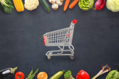 Pazar sepeti karanlık bir yüzey üzerinde sebze çevrili. Kavramı.