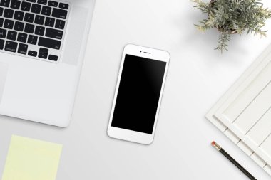 Ofis büro dizüstü bilgisayar yanında telefon. Temiz, düz kompozisyon app tasarım promosyon için lay.