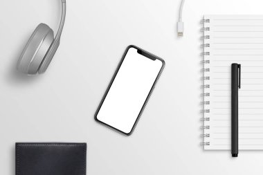 Ofis Masası çevrili kulaklıklar, pad, kalem, şarj cihazı, m-cüzdan ile akıllı telefon. Kahraman başlığı sahne. Mockup, app tasarım sunum için izole ekran.