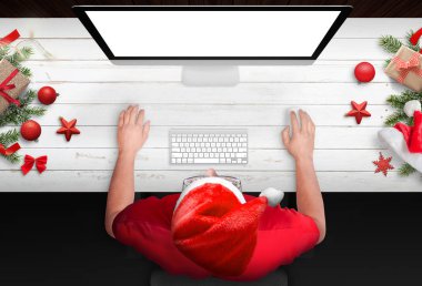 İş ile izole, boş perde mockup için bilgisayarda bir adamın. Noel ağacı, hediyeler ve süslemeleri yanında beyaz ahşap çalışma masası. Üstten görünüm.