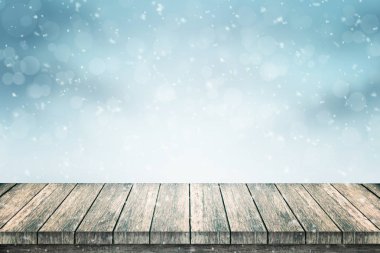 Boş ahşap masa ve ürün tanıtımı için kar. Işıklar ve bokeh ile mavi arka plan.