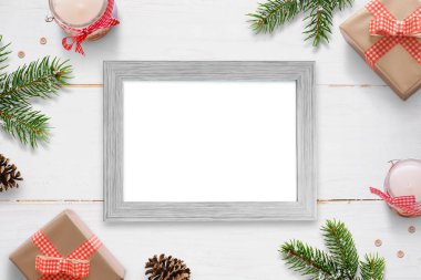 Yatay fotoğraf çerçevesi Noel yılbaşı hediyeleri, ağaç dalları ve süslemeleri ile çevrili. İzole kare fotoğraf mockup için.