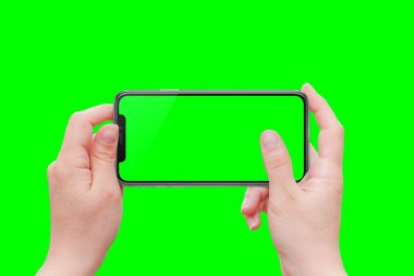 Kadın elinde telefon. Yatay konum. Yeşil izole, video editörleri için renk anahtarı.