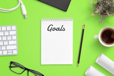 İş hedefleri listesinin hazırlanması. Klavyeli ofis masası, bardaklar, bir fincan kahve, projeler. Üstte görüntü.