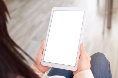 Tablet mockup kadın için izole, boş ekran ile portre eller. Omuz üzerinden görüntüleyin. Oda arka planda.