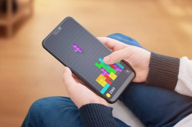 Popular tetris game on modern smart phone. Concept of technology development children intelligence. clipart