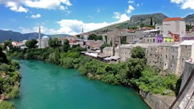 Mostar'daki eski şehrin eski köprüden görünümü. Şehir merkezindeki eski zanaat dükkanlarına bir göz atın. Yeşil Neretva Nehri köprünün altından akar. Güneşli bir gün.
