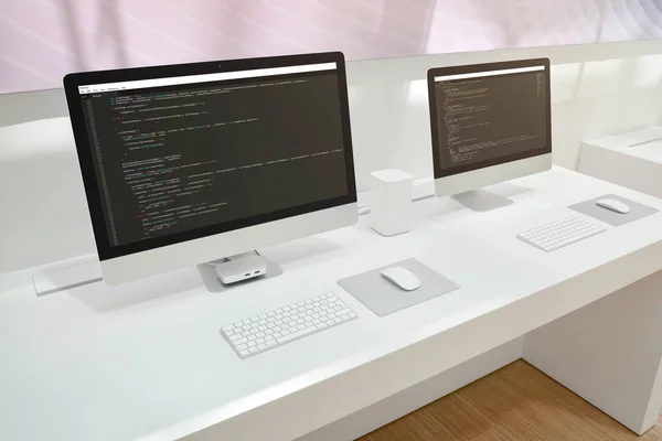 Developer\'s office. Two computer displays with code editors.