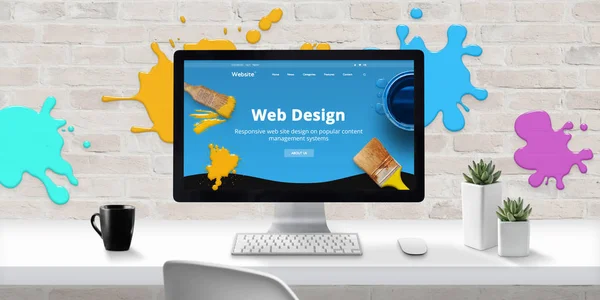 Web design studio with modern web site theme on computer display with color drops on brick wall. Concept of creating modern and colorful web sites.