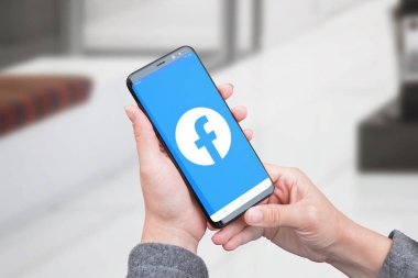 Saraybosna, Bosna-Hersek - 14 Temmuz 2019: Facebook sosyal ağ uygulamasında yeni Facebook logosu kadın elinde modern akıllı telefon.