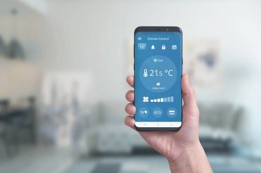 İklim kontrol uygulaması ile akıllı telefon. Basit bir telefon uygulaması ile çevre konforu otomasyonu kavramı.