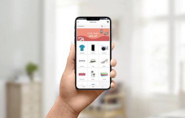Mağaza uygulaması konseptinde indirim reklamı. Akıllı telefon tutan ve internetten alışveriş yapıyor. Close.