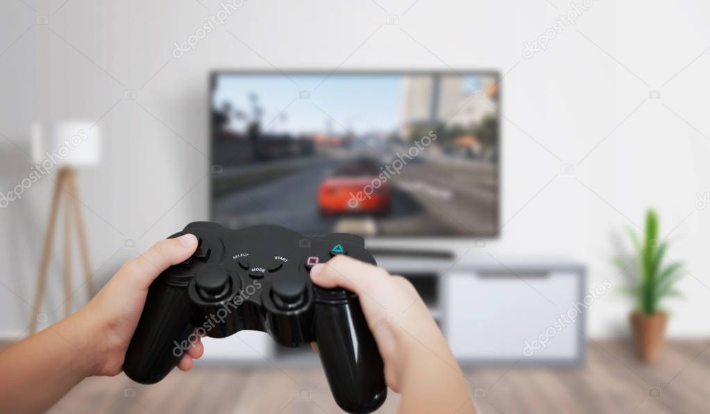 Boy play game on large TV in living room. Concept of digital entertainment, gaming industry.