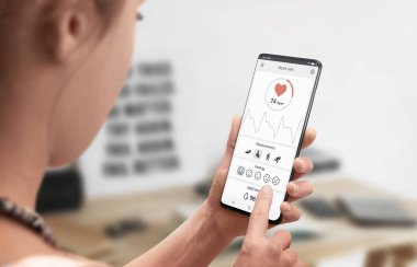 Cep telefonu konseptinde mobil uygulama ve sensör ile kalp atış hızını ölçme. Close.