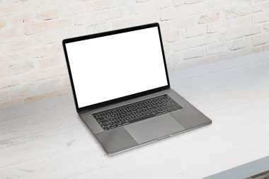 Laptop temiz masada. Model, uygulama veya web sitesi sunumu için izole ekran. Arkaplanda tuğla duvar.