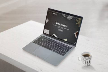 Dizüstü bilgisayarda web tasarımı konsepti web sayfası. Yanında bir fincan kahve olan temiz bir sahne. Web geliştirme veya tasarım stüdyosu konsepti.