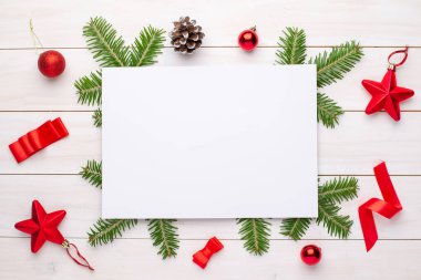 Empty paper for greeting text or logo surrounded with Christmas fir branches and decorations.