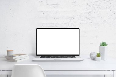 Ofis masasında tek ekran modeliyle modern dizüstü bilgisayar. Bitkiler ve kitaplar. Tanıtım metninin arkaplanındaki beyaz duvarı temizle