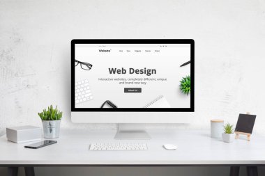 Web tasarım şirketi web sitesi konsepti bilgisayar ekranında. Modern düz tasarım web sitesi. Bitkiler, telefon, klavye ve fareli ofis masası.