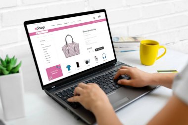 Ekommerce web sitesi konsepti üzerinden online alışveriş yapmak. Kadın çantasını bulmak için dizüstü bilgisayar kullanıyor. Yakın plan.