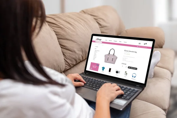Shopping online from the comfort of home concept. Woman holding laptop and search for bag through online web store