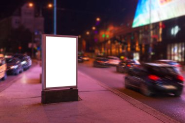Geceleri şehirde reklam panosu maketi. Arka planda arabalar olan cadde