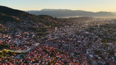 Saraybosna şehrinin geniş panoramik drone görüntüsü, kamera yavaşça sola hareket ediyor