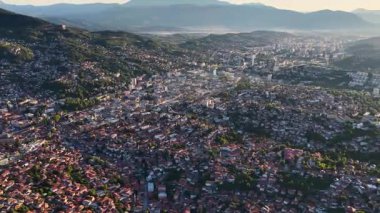 Saraybosna şehrinin geniş panoramik görüntüsü evler, sokaklar ve dağlar, sağa hareket eden kamera