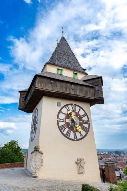 Schlossberg tepesindeki Uhrturm saat kulesi. Büyük saat yüzlü ve tahta kanatlı.