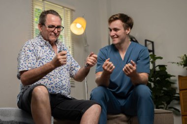 Son sınıf öğrencisi terapistle el egzersizi yapıyor. Rehabilitasyon ya da fizik tedavi seansları sırasında evde tutuş güçlendirici kullanıyor..