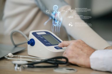 Doktor, yansıtılan hologramla dijital tansiyon monitörü, otomatik kan basıncı monitörü kullanıyor..