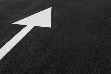 Yönü tanımlamak için asfalt üzerinde beyaz ok