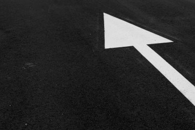 Yönü tanımlamak için asfalt üzerinde beyaz ok