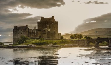 Eilean Donan Kalesi ile bulutlu gün batımı gök dağlık İskoçya manzara seyahat Büyük Britan