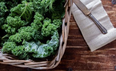 Sepet ve gün ışığından yararlanma superfood sebze natürmort üzerinde ahşap arka plan üstten görünüm bıçakta yeşil lahana